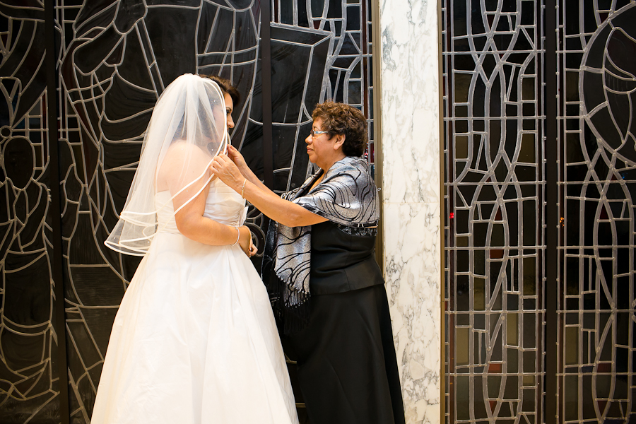 Mother of the bride placing veil on her daughter on the day of her Santa Monica wedding. 