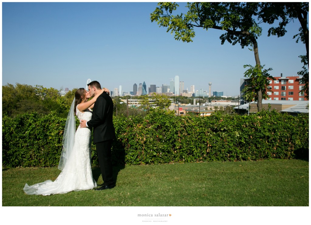 Bride and groom kissing with the Dallas skyline in the background at the Belmont Hotel. Dallas wedding photography.